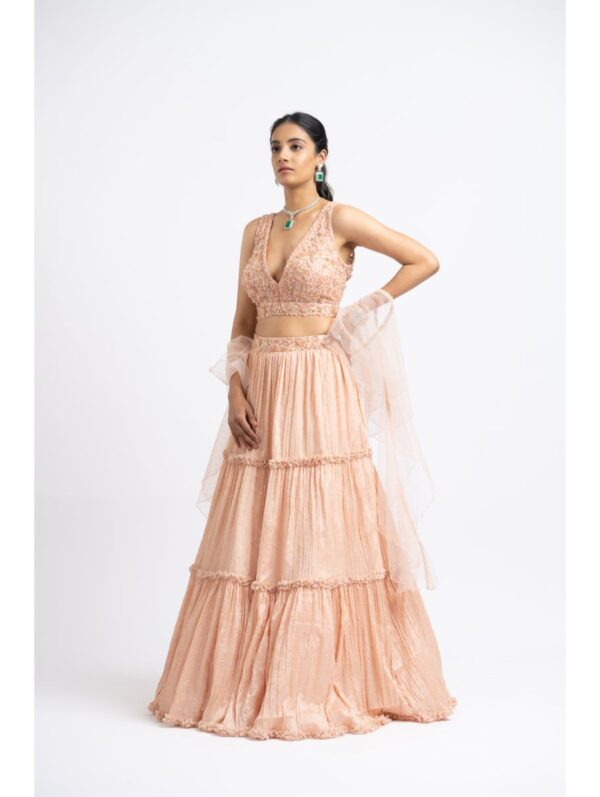 Nikita Gujral- PEACH CRUSHED CHIGNON TIERRED LEHENGA WITH NET CHOLI AND DUPATTA
